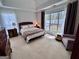Bright main bedroom featuring a king-sized bed, large windows, and an elegant seating area with neutral toned decor at 403 Rock Creek Dr, Peachtree City, GA 30269