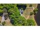 Aerial view of a charming home secluded by lush trees and landscaping with a sprawling backyard and a fence at 423 Bear Creek Trl, Hampton, GA 30228