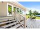 Inviting back deck with outdoor seating, offering a tranquil view of the serene lake and lush green lawn at 423 Bear Creek Trl, Hampton, GA 30228