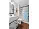 Bathroom showcasing dark wood floors, a walk-in shower with glass door, and stylish vanity at 423 Bear Creek Trl, Hampton, GA 30228