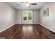 Light-filled room with hardwood floors, a ceiling fan, and a large window with tree views at 423 Bear Creek Trl, Hampton, GA 30228