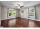 Sunny bedroom features hardwood floors, a ceiling fan, and a large window with a street view at 423 Bear Creek Trl, Hampton, GA 30228
