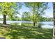Scenic lake view showcasing mature trees, lush green grass, and natural beauty at 423 Bear Creek Trl, Hampton, GA 30228