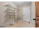 Functional laundry room with built-in shelving and tile flooring at 423 Bear Creek Trl, Hampton, GA 30228