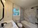 Bright bathroom featuring a shower-over-tub with marble-style tiled walls, and a modern vanity at 2571 Stanford Dr, Ellenwood, GA 30294