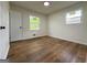 Bright bedroom featuring two windows, hardwood floors, and a white door at 2571 Stanford Dr, Ellenwood, GA 30294