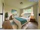 Bright staged bedroom with hardwood floors, neutral walls, and a window providing natural light at 2571 Stanford Dr, Ellenwood, GA 30294