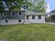 Charming two-story home features a covered carport, gray and white paint scheme, and a well-manicured front lawn at 2571 Stanford Dr, Ellenwood, GA 30294