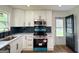 Modern kitchen boasts white cabinets, stainless steel appliances, and sleek countertops, perfect for culinary enthusiasts and entertaining at 2571 Stanford Dr, Ellenwood, GA 30294