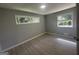 A sunlit bedroom with a view, featuring two windows and wood-style laminate flooring at 2836 Belaire Cir, Doraville, GA 30340