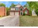 Two-story brick home featuring an attached two-car garage and a manicured front lawn at 122 Ardenlee Dr, Peachtree City, GA 30269