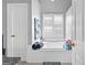 Bright main bathroom featuring a soaking tub with white tile surround and shuttered windows at 122 Ardenlee Dr, Peachtree City, GA 30269