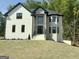 Elegant two-story home featuring a white brick facade, stone accents, a manicured lawn, and a striking black roof at 409 Saint Surrey Way, Ellenwood, GA 30294