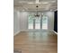 Bright living room with hardwood floors, modern chandelier, white trim, and large windows for an open, airy feel at 409 Saint Surrey Way, Ellenwood, GA 30294