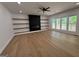 Spacious living room with hardwood floors, a sleek fireplace, floating shelves, and natural light from large windows at 409 Saint Surrey Way, Ellenwood, GA 30294