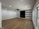 Open living room featuring hardwood floors, recessed lighting, a fireplace with shelves, and large windows at 409 Saint Surrey Way, Ellenwood, GA 30294