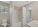 Bathroom featuring a tub, toilet, window, and entry to the main bedroom and bathroom at 8032 Highland Pkwy, Fairburn, GA 30213