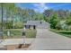 Inviting single-Gathering home with a spacious driveway, lush lawn, and mature trees, perfect for suburban living at 8032 Highland Pkwy, Fairburn, GA 30213
