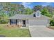 Charming single-story home featuring a well-maintained lawn, a two-car garage, and beautiful stone accents at 8032 Highland Pkwy, Fairburn, GA 30213