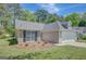 Well-manicured lawn surrounds a lovely home with stone and siding accents, complemented by a spacious two-car garage at 8032 Highland Pkwy, Fairburn, GA 30213
