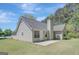 Rear view showcasing siding, the roof, and patio with a generous lawn at 8032 Highland Pkwy, Fairburn, GA 30213