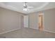 Spacious bedroom with tray ceiling and neutral walls and carpet leading to en suite bathroom and closet at 8032 Highland Pkwy, Fairburn, GA 30213