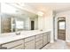 Bathroom featuring double sinks, quartz countertop, and a large mirror at 1700 Cobblefield Cir, Dacula, GA 30019