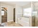 Luxurious bathroom with a soaking tub, separate shower, and tile flooring at 1700 Cobblefield Cir, Dacula, GA 30019