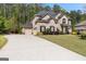 Stately brick two-story home featuring a three-car garage, a large yard, and professionally landscaped shrubbery at 266 Shellbark Dr, Mcdonough, GA 30252