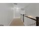 Upstairs hallway with carpet and a wooden railing, featuring an open floor plan at 266 Shellbark Dr, Mcdonough, GA 30252