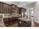 Gourmet kitchen features dark wood cabinets, granite countertops, stainless steel appliances, and a kitchen island at 266 Shellbark Dr, Mcdonough, GA 30252