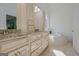 Bathroom with dual vanities, granite countertops, and a relaxing soaking tub by the window at 671 Ellison Rd, Tyrone, GA 30290