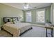 Bedroom with warm green walls featuring a queen bed, a nightstand, and two windows at 671 Ellison Rd, Tyrone, GA 30290