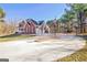 Brick home with a circular driveway, attached garage and a basketball court at 671 Ellison Rd, Tyrone, GA 30290