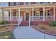 Inviting front porch with brick steps, white railings, and ceiling fans at 671 Ellison Rd, Tyrone, GA 30290