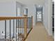 Upstairs hallway with wood and iron railing with great light from window at end of hall at 671 Ellison Rd, Tyrone, GA 30290