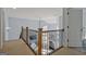 Upstairs hallway with wood and iron railing looking down into the living area at 671 Ellison Rd, Tyrone, GA 30290