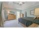 Spacious main bedroom with a tray ceiling, light blue walls, and light-colored carpet at 671 Ellison Rd, Tyrone, GA 30290