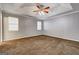Spacious bedroom with carpet, tray ceiling, and natural light from two windows at 113 Elmwood Dr, Hampton, GA 30228