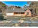 Charming brick home featuring a well-maintained lawn, attached garage, and covered front porch at 113 Elmwood Dr, Hampton, GA 30228