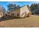 Side exterior of home features a spacious yard and mature trees, creating a private and serene setting at 113 Elmwood Dr, Hampton, GA 30228
