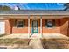 Close up of a brick home featuring a decorative front door with green trim and adjacent windows at 113 Elmwood Dr, Hampton, GA 30228