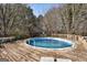 Backyard pool with wood deck surround, with an above-ground design and ladder access at 113 Elmwood Dr, Hampton, GA 30228