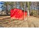 Red storage shed with double doors, nestled amongst the trees in the yard at 113 Elmwood Dr, Hampton, GA 30228