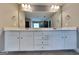 Bathroom vanity featuring dual sinks, white cabinetry, modern fixtures, and a large mirror at 1820 Cobblefield Cir, Dacula, GA 30019