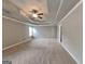 Spacious bedroom featuring neutral carpet, a tray ceiling with fan, and bright natural light at 1820 Cobblefield Cir, Dacula, GA 30019