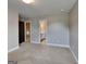Spacious carpeted bedroom has neutral walls and a connecting bath and stairway at 1820 Cobblefield Cir, Dacula, GA 30019