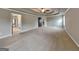 Large bedroom with neutral carpet, tray ceiling with ceiling fan, and multiple doors at 1820 Cobblefield Cir, Dacula, GA 30019