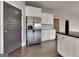 Modern kitchen with stainless steel appliances, white cabinets, and a gray accent door at 1820 Cobblefield Cir, Dacula, GA 30019
