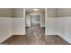 Inviting living room featuring hardwood floors, wainscoting, and open doorway to other living spaces at 1820 Cobblefield Cir, Dacula, GA 30019